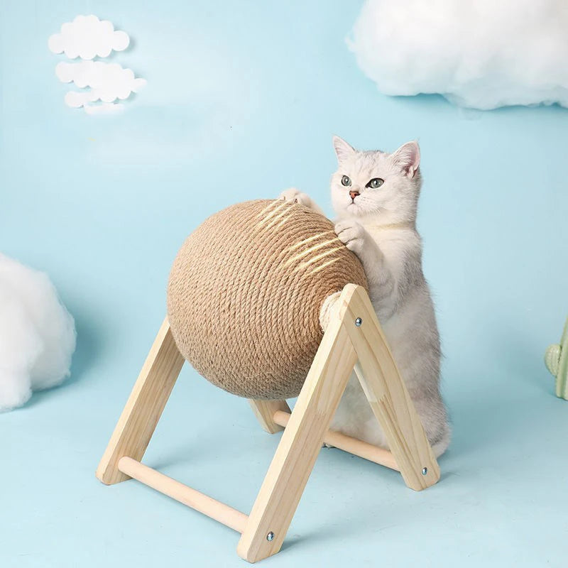 Cat playing with a beige ball on a wooden stand against a light blue background