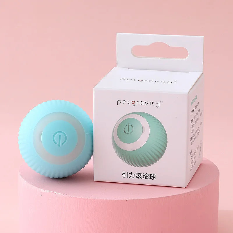 Light blue rolling ball with 'petgravity' branding next to its packaging on a pink background