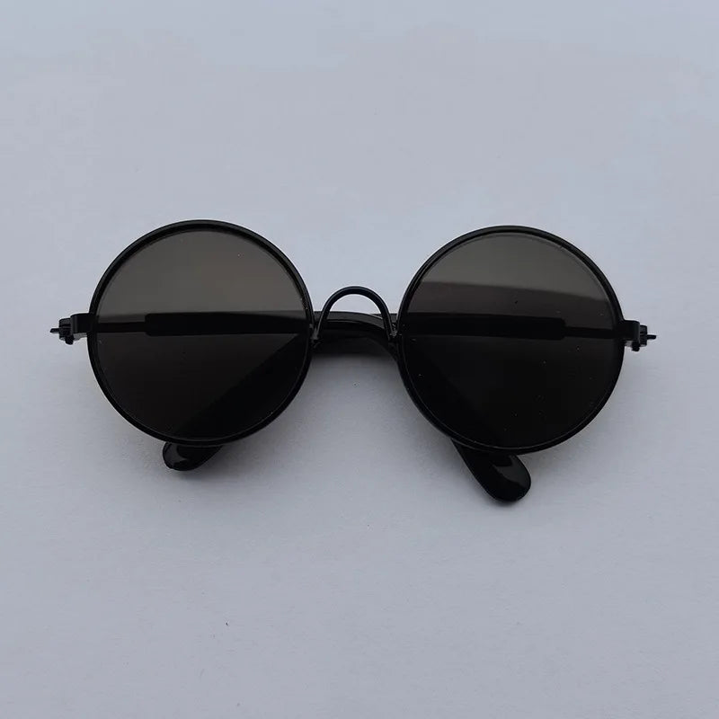 Black round sunglasses on a light gray background