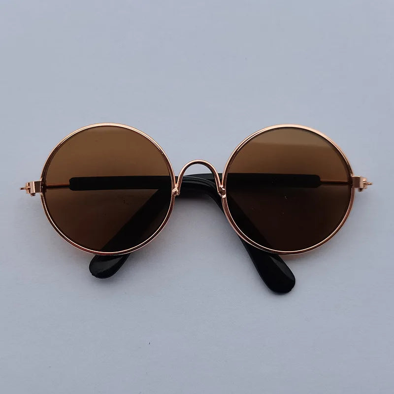Round sunglasses with rose gold frame and dark lenses on a light gray background