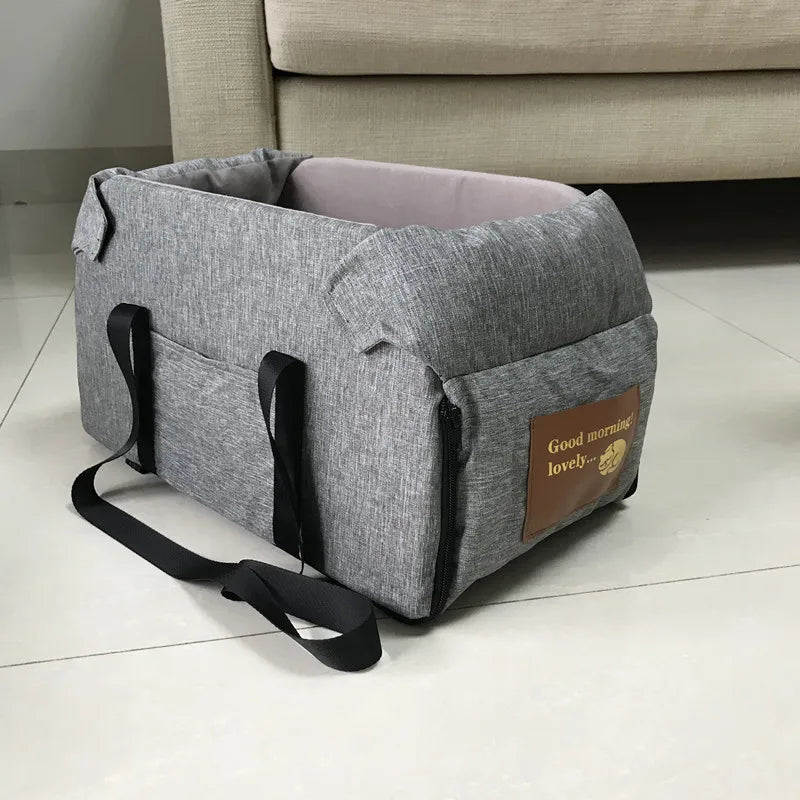 Gray pet carrier with a brown label on a tiled floor.