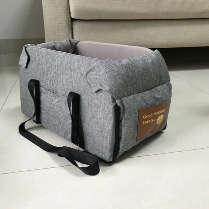 Gray pet carrier with a brown label on a tiled floor.