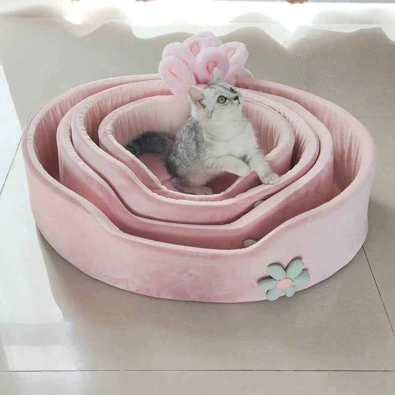 Pink pet bed with a cat inside on a light background