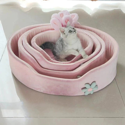 Pink pet bed with a cat inside on a light background