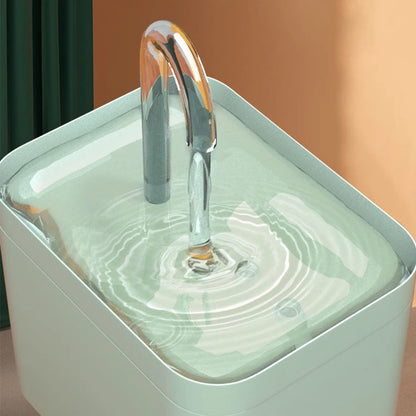 Metallic faucet pouring water into a square container with a blurred background
