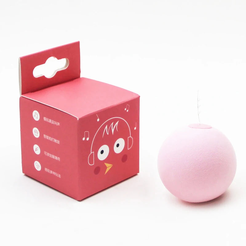 Pink spherical product next to its red packaging box on a white background