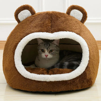 Cat lying inside a brown pet bed with bear ears on a light wooden floor.