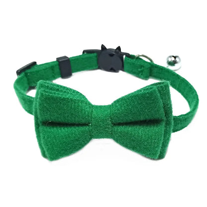 Green bow tie cat collar with a bell on a white background