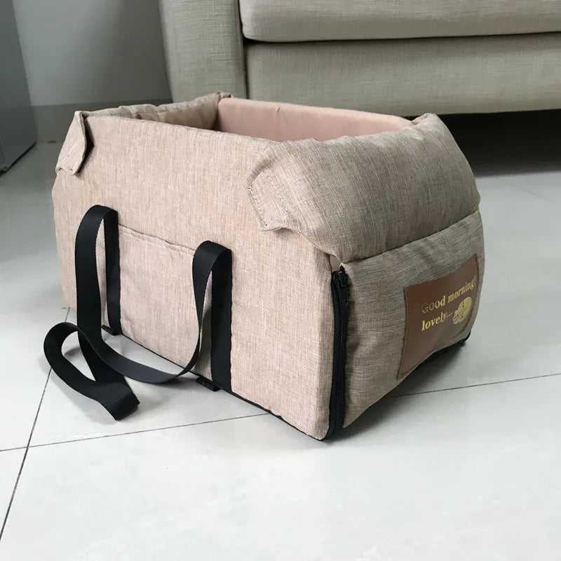 Beige pet carrier with black straps on a white floor