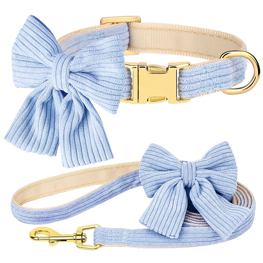 Dog collar and leash set with large blue bows and gold hardware on a white background