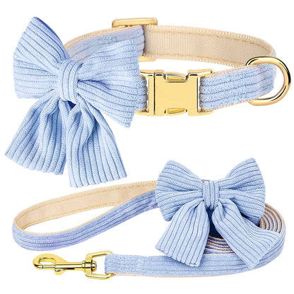 Dog collar and leash set with large blue bows and gold hardware on a white background