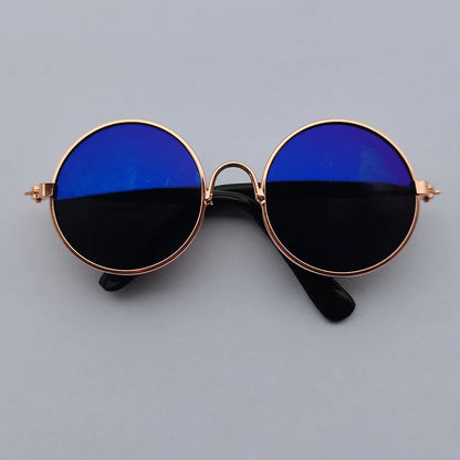 Round sunglasses with blue lenses and gold frame on a gray background