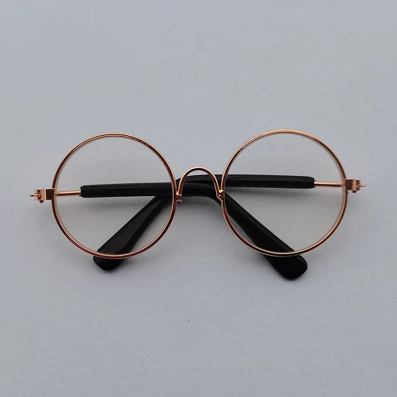 Round eyeglasses with rose gold frame and black arms on a light gray background