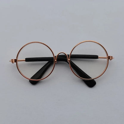 Round eyeglasses with rose gold frame and black arms on a light gray background
